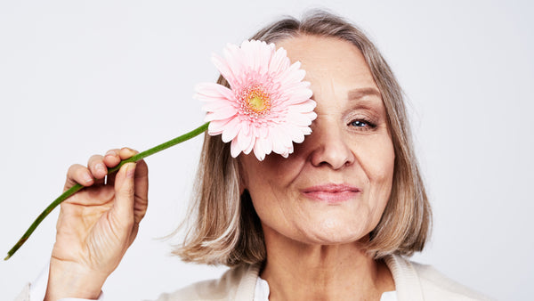 Frau mit Blume über dem Gesicht